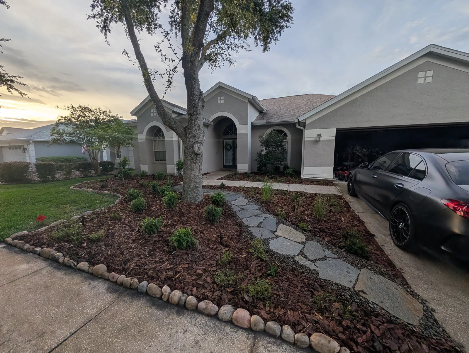Native front yard with flagstone pathway, river rock, and Florida native plantings installed by Living Spaces Gardening in Tampa Bay FL
